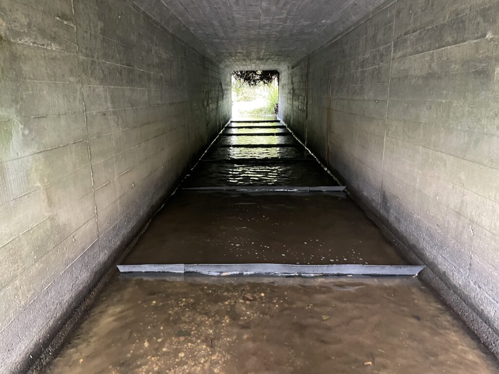 Interior of concrete box culvert with completed FlexiBaffle baffle installation creating stepped fish passage pools